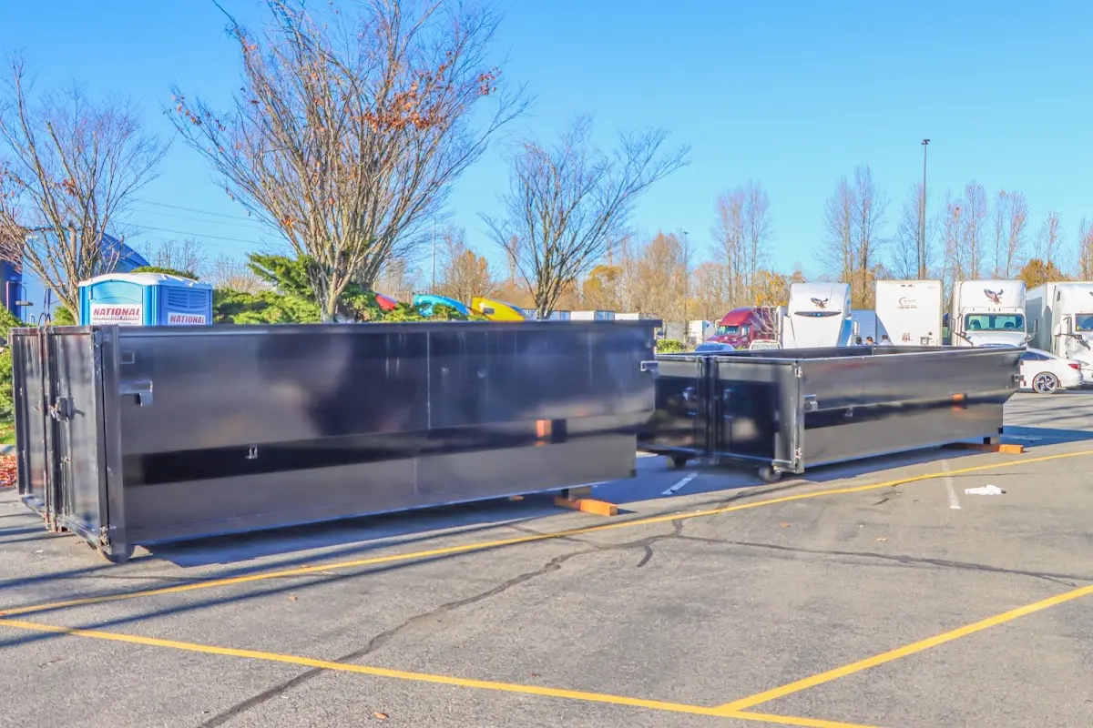 Professional dumpster rental service with roll-off container on residential driveway in Daphne